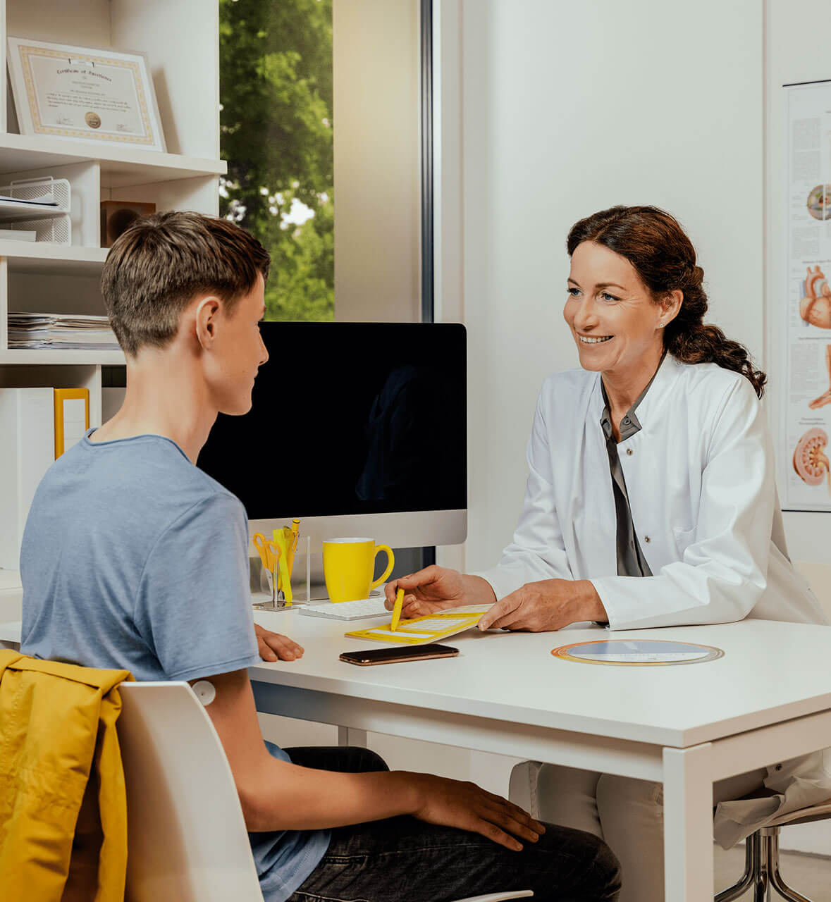 Patient sitzt seiner Ärztin gegenüber.