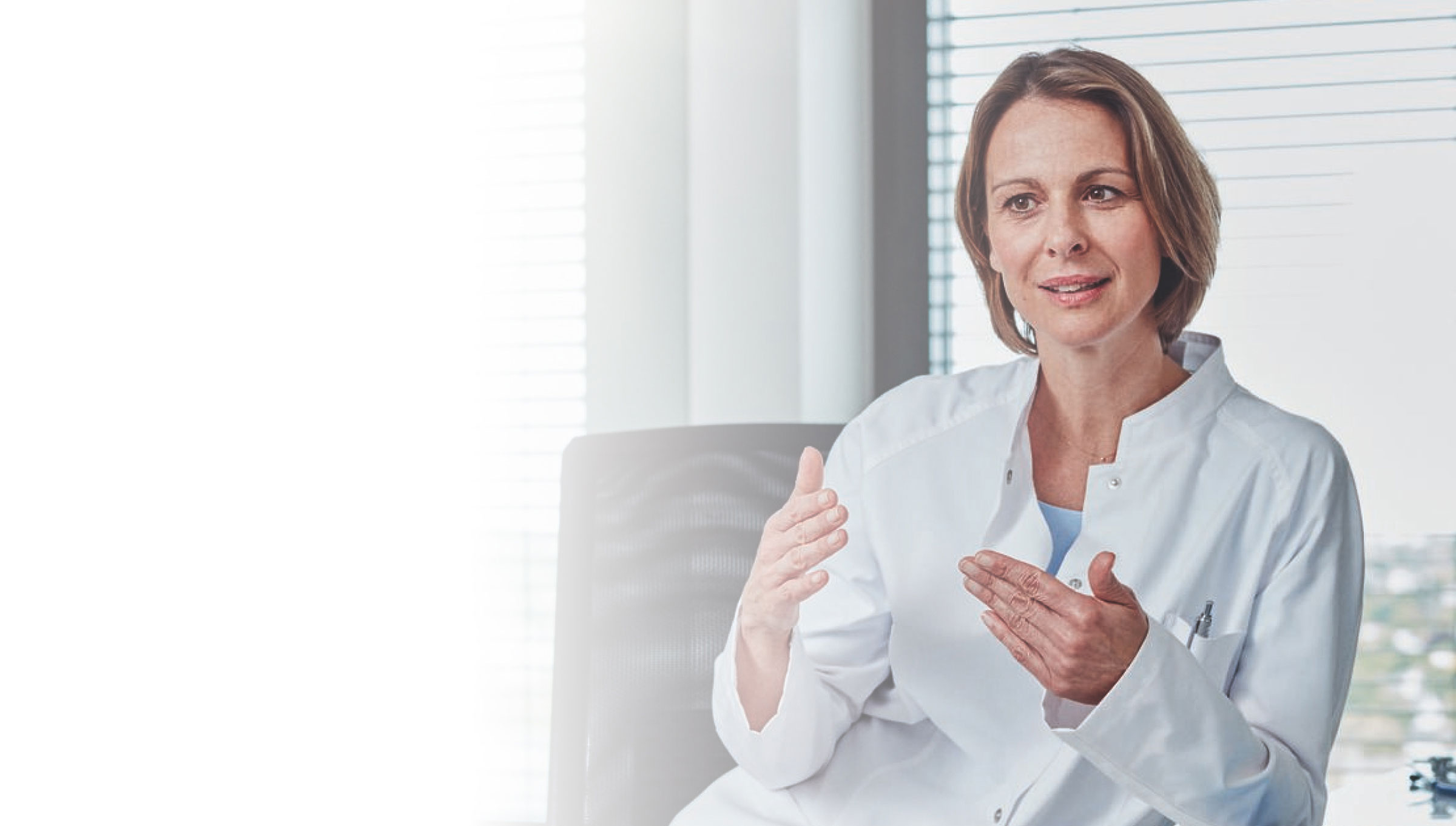 Ärztin im weißen Kittel erklärt etwas im Beratungsgespräch.