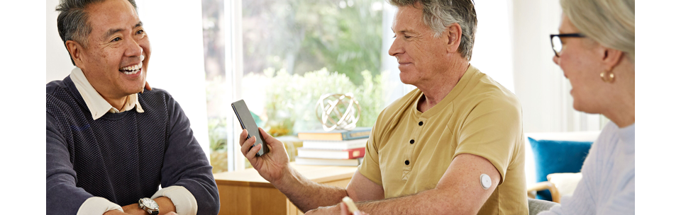Man with FreeStyle Libre 2 Plus sensor checking his phone
