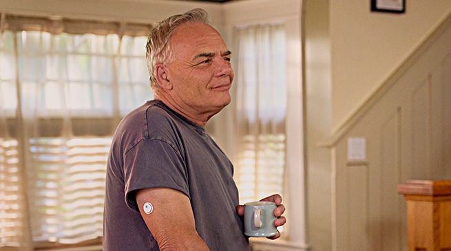 Man in a kitchen wearing Libre 3 Plus sensor