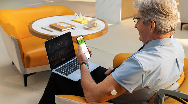 Man wearing a Libre sensor and checking his mobile device