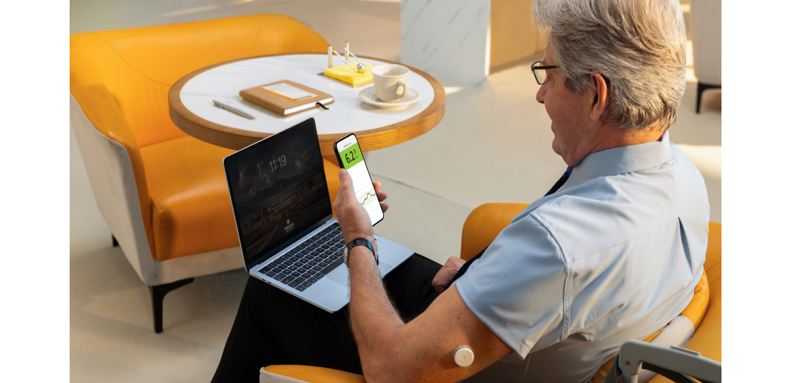 Man wearing a Libre sensor and checking his mobile device