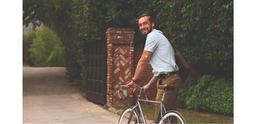 an image of a man moving his bicycle with a visible sensor on his arm
