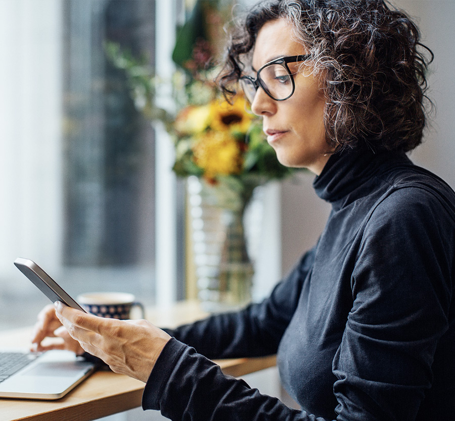 Woman working on laptop and mobile phone