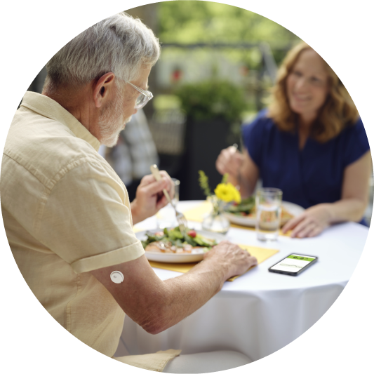 Man eating outdoors with a visible sensor on his arm