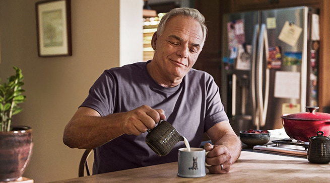 Man wearing FreeStyle Libre 3 Plus sensor in kitchen