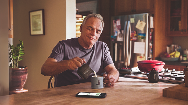 Man wearing FreeStyle Libre 3 Plus sensor in kitchen