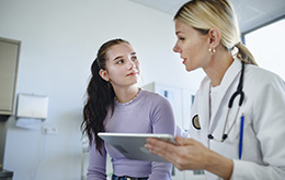 Doctora en su consulta con paciente joven con diabetes tipo 1