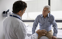 Médico en su consulta con un paciente explicándole los factores de riesgo de la diabetes tipo 2