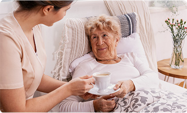 Imagen de una mujer sosteniendo la mano de una anciana.