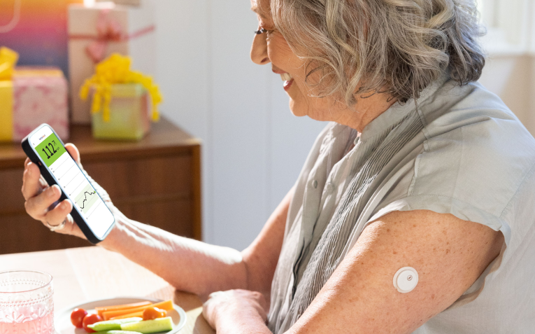 A woman checks her glucose levels on her smartphone 