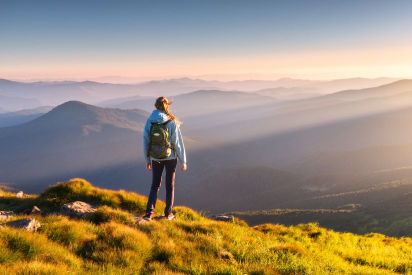 Magnifique vue avec coucher de soleil et femme qui regarde au loin 