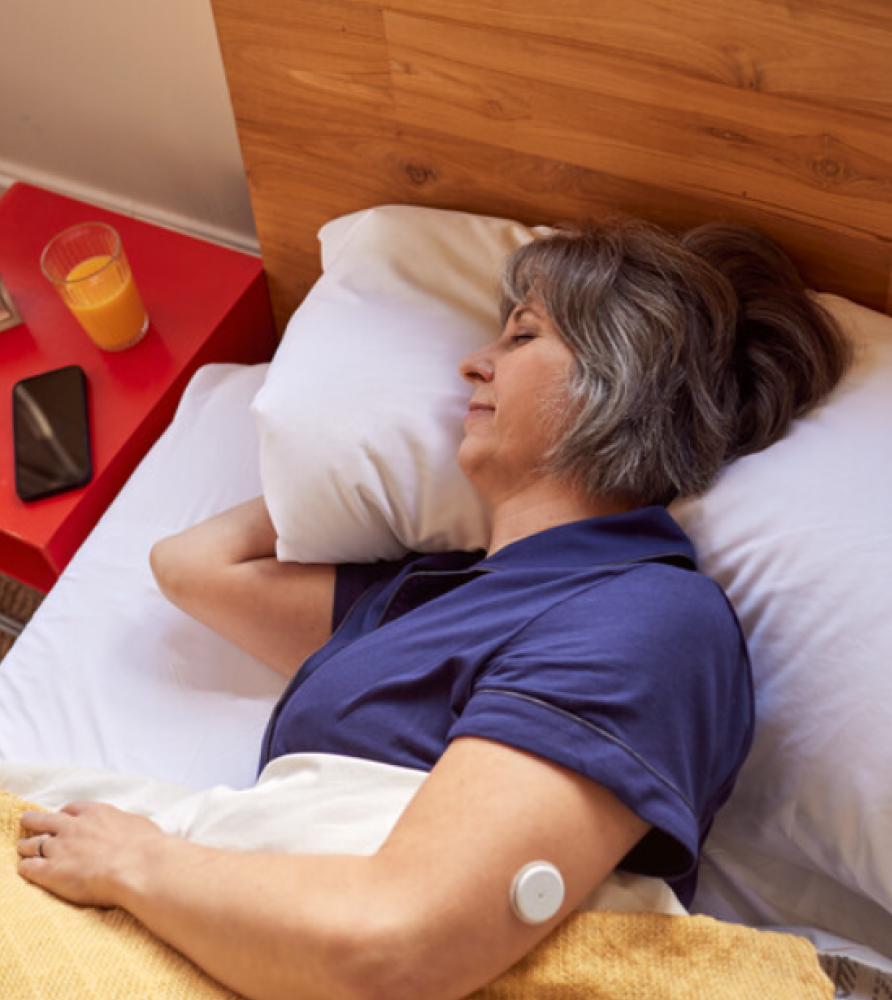 A girl sleeping with FreeStyle Libre 2 sensor visible on the back of her upper arm