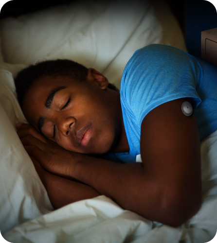 A girl sleeping with FreeStyle Libre 2 sensor visible on the back of her upper arm