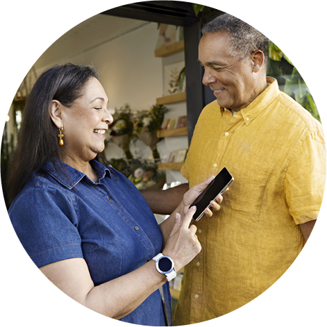 Man and woman with the FreeStyle Libre 2 sensor looking at their glucose levels on their phone 