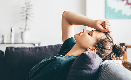 Vrouw liggend op bank, voelt zich niet lekker