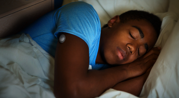Ung mann sover med sin FreeStyle Libre sensor