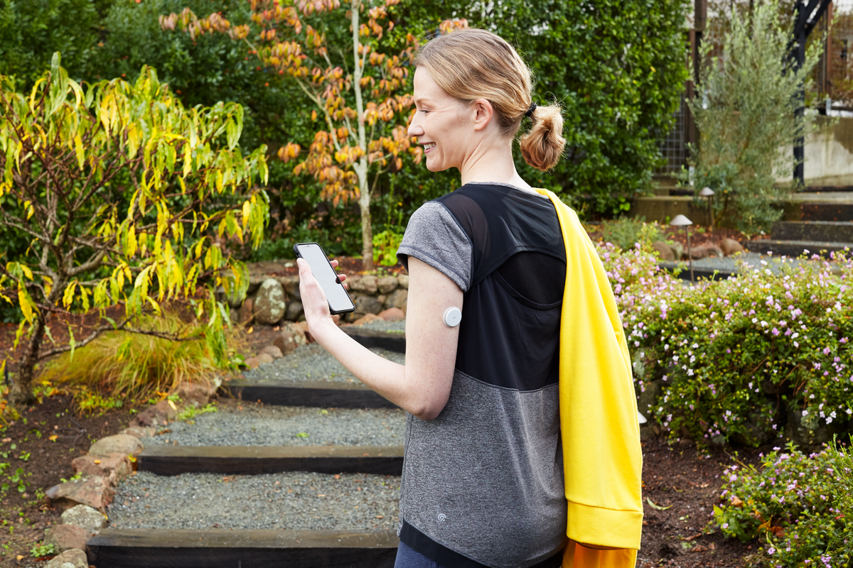 Man and woman with the FreeStyle Libre 2 sensor looking at their glucose levels on their phone 