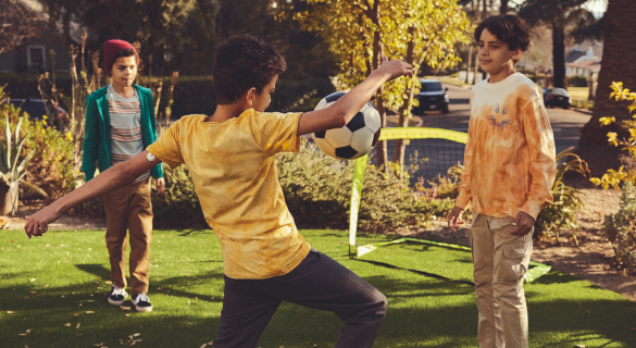A FreeStyle Libre System user standing in the football field looking at his phone.