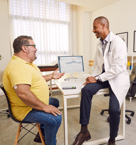 A healthcare professional and a patient looking at a computer monitor together.