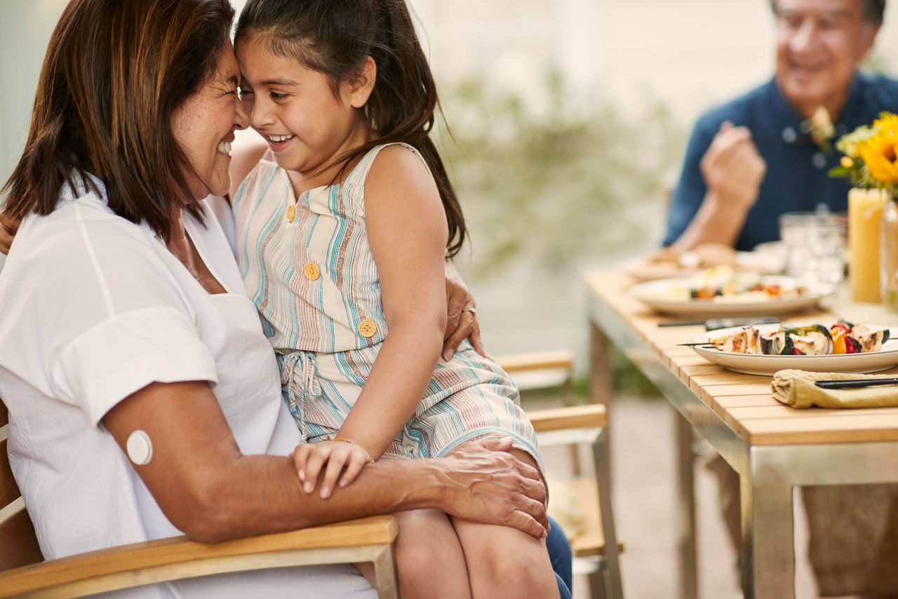 A FreeStyle Libre 2 Plus patient hugging her granddaugter at a birthday 