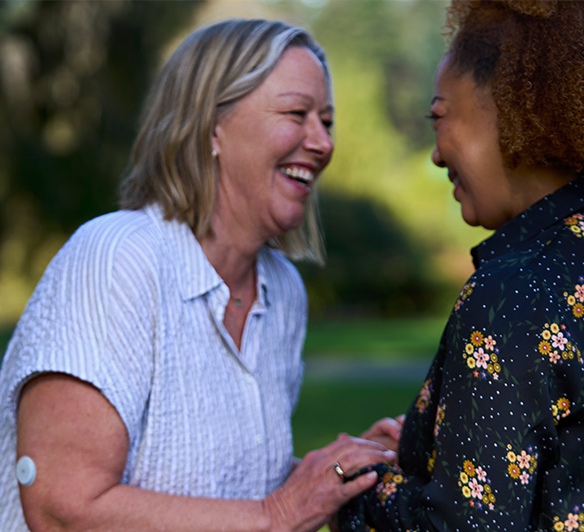 A woman and her friend laughing in a garden
